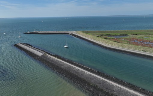 Luchtfoto van strekdammen en zeilboten op het water in Zeeland