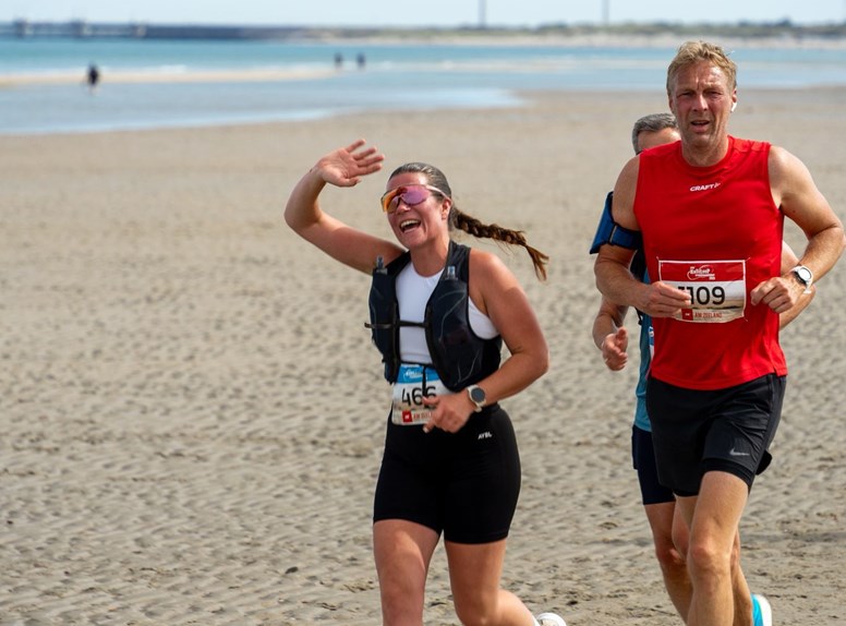 Hardlopers over een Zeeuws strand tijdens de Kustloop Vrouwenpolder