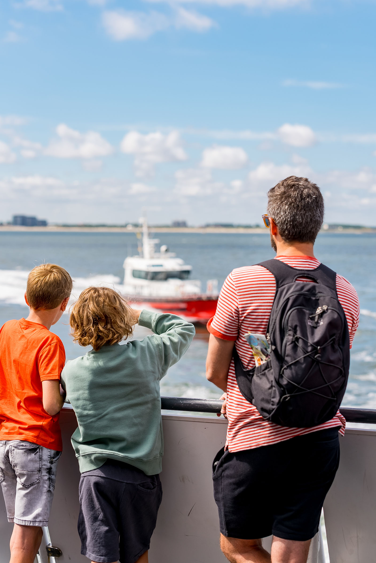 Mensen die over het water uitkijken vanaf de Westerschelde Ferry