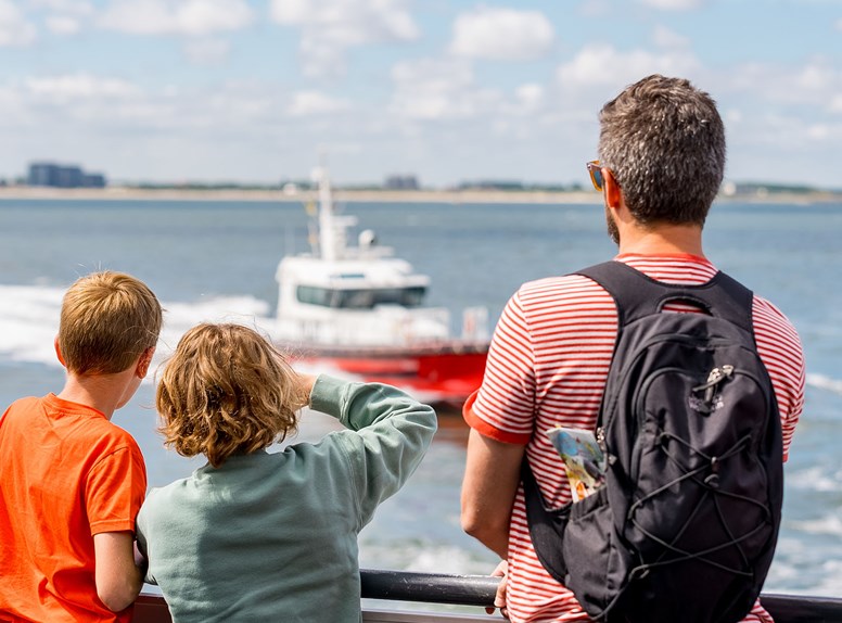 Mensen die over het water uitkijken vanaf de Westerschelde Ferry